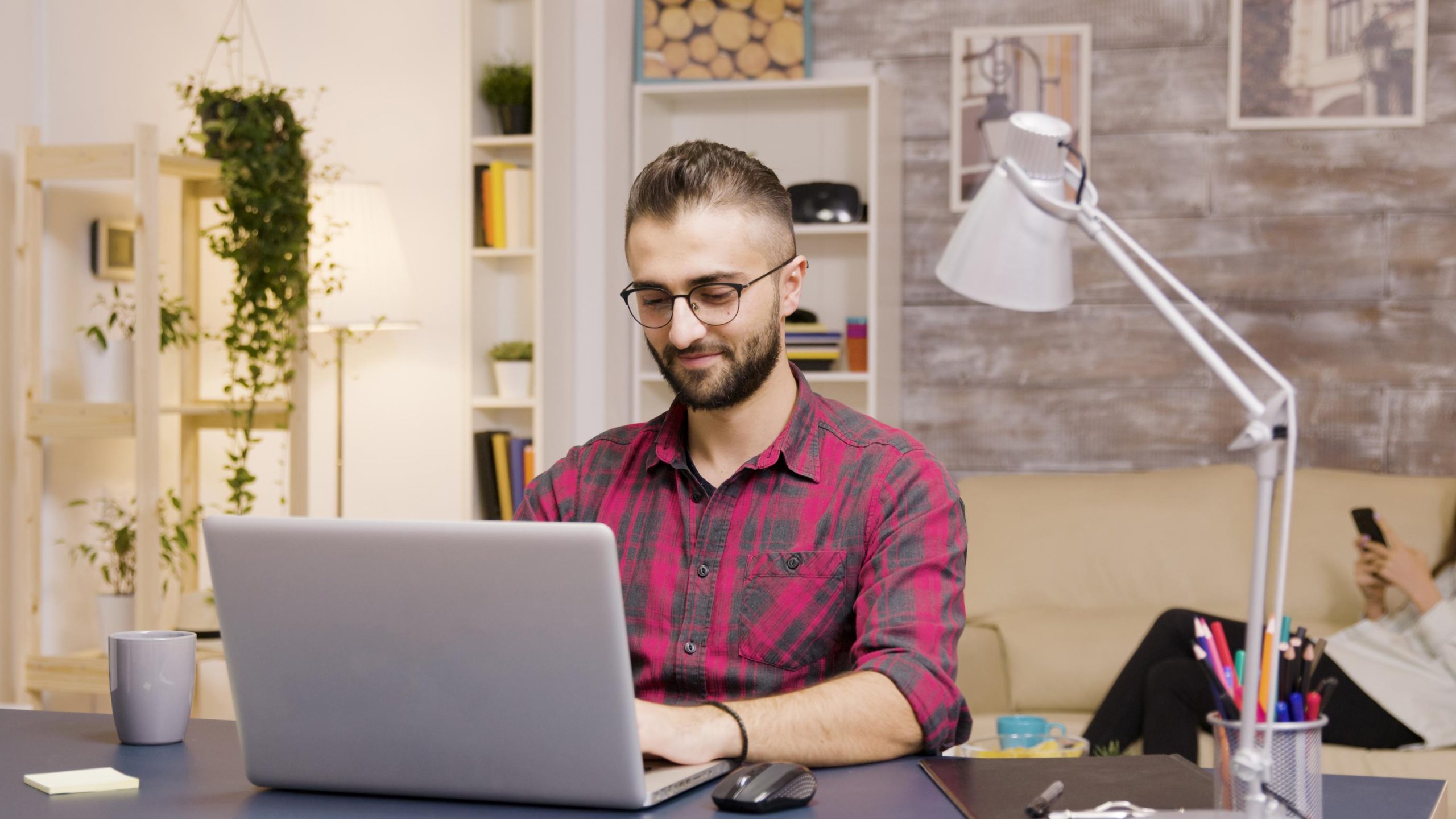 homme riant en travaillant au freelancing sur un ordinateur portable dans le salon