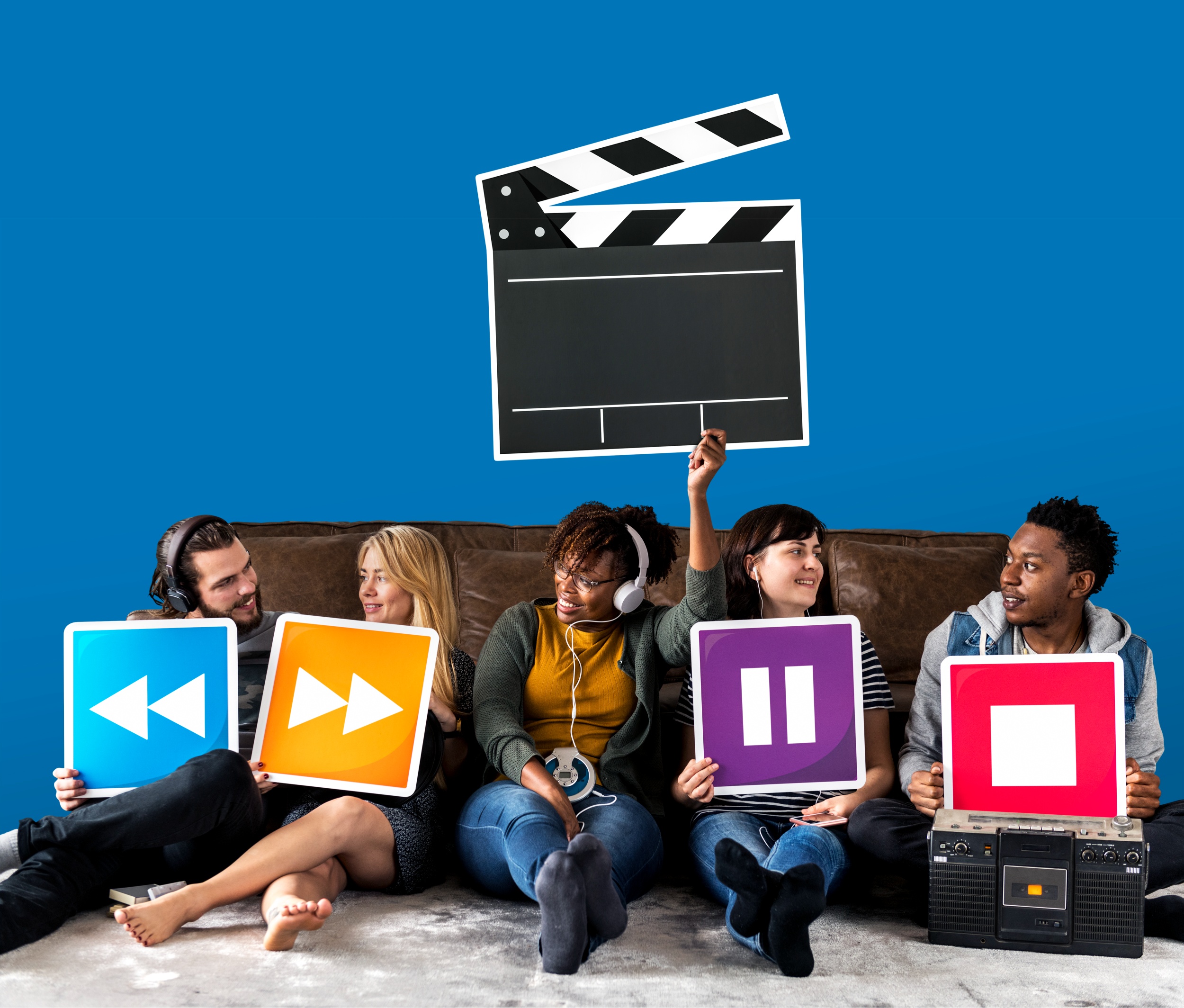 Groupe de personnes africaines et internationales tenant des icônes de contrôle multimédia (lecture, pause, stop, avance et retour) avec une icône de clap de cinéma, illustrant le streaming et le divertissement numérique.