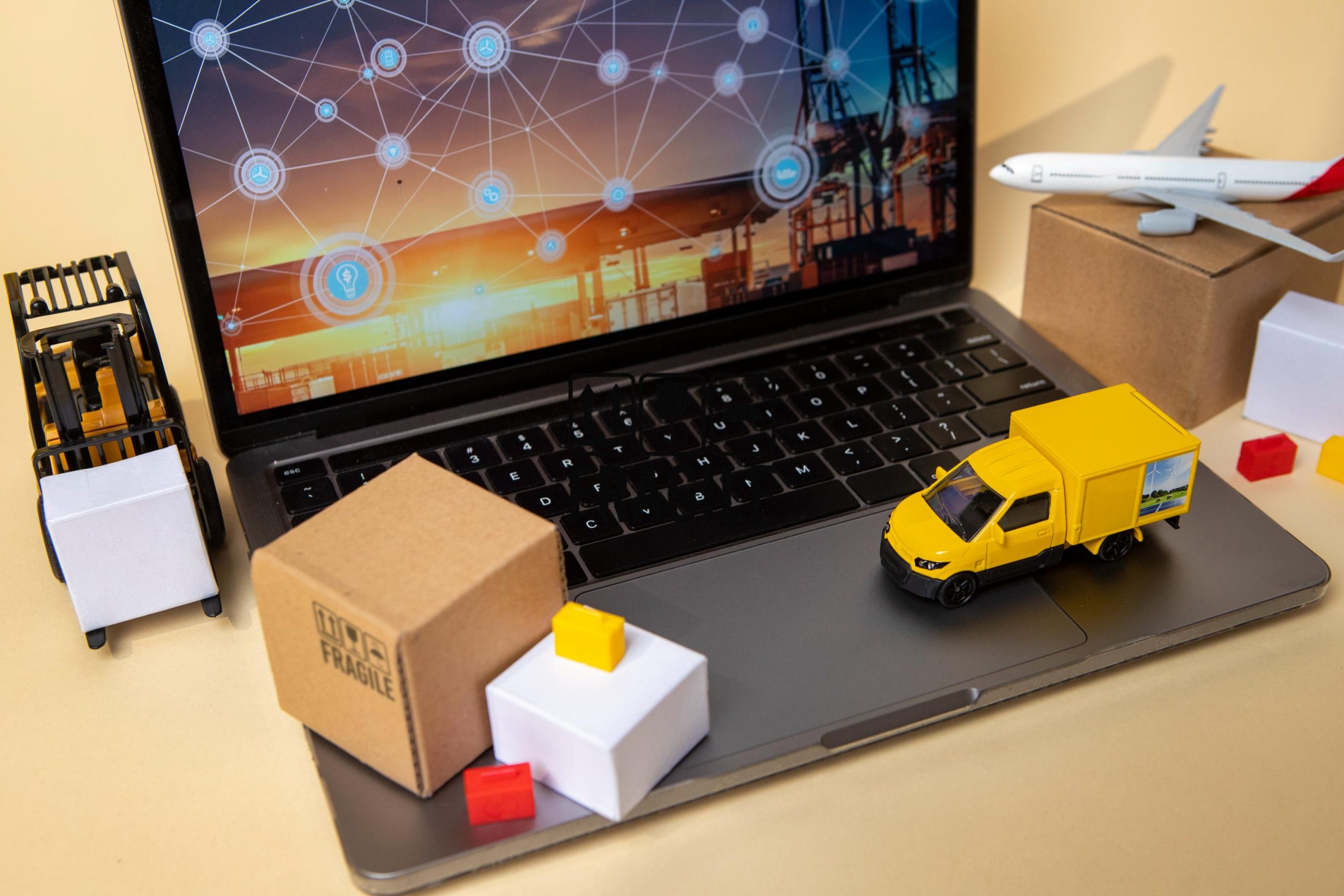 Laptop avec un petit camion de transport sur l'écran, illustrant la logistique et le transport rapide dans le e-commerce.