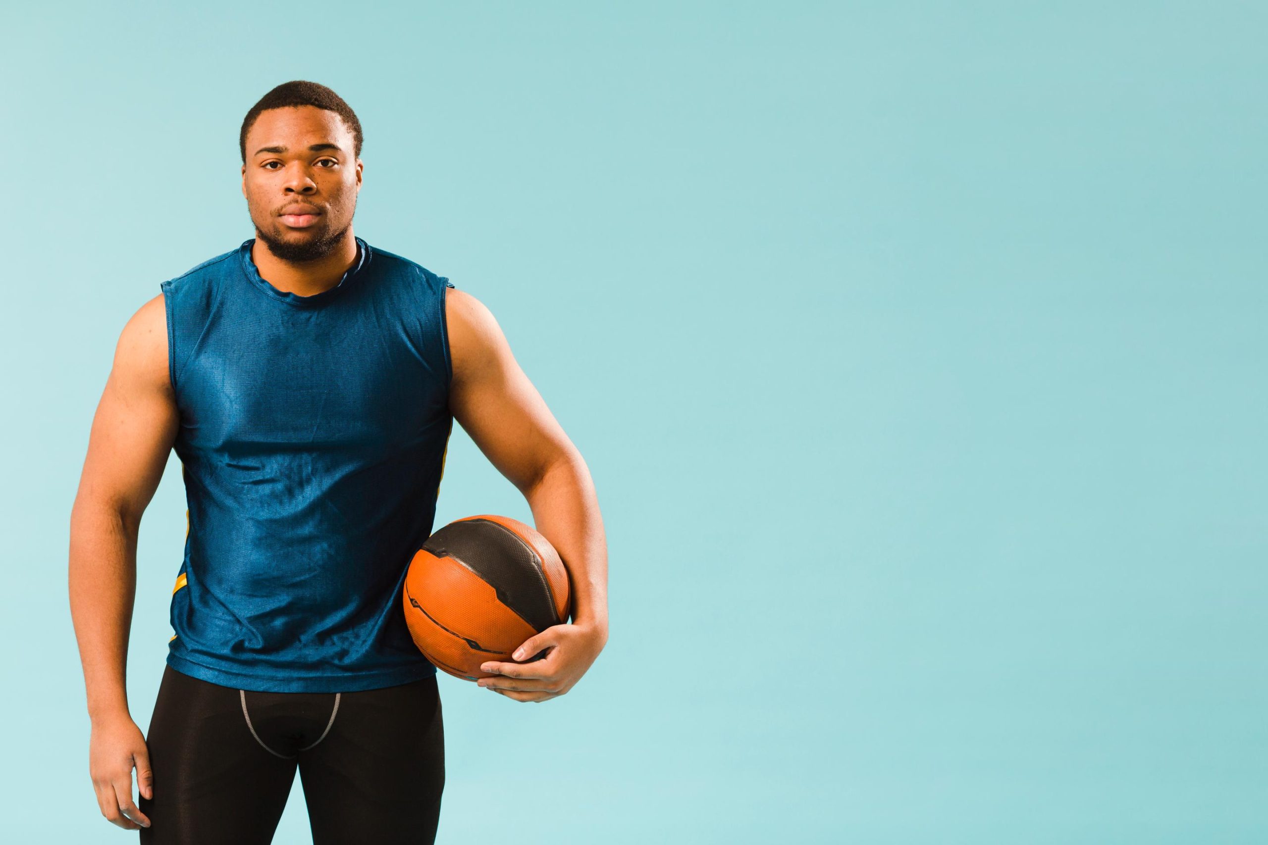 Homme africain tenant un ballon de basketball, symbole de la passion et du talent sportif en Afrique.
